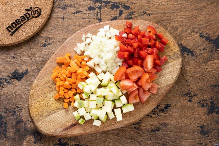 В это время подготовьте остальные овощи. Репчатый лук, морковь, болгарский перец нарежьте кубиками одинакового размера. Помидоры порежьте дольками.