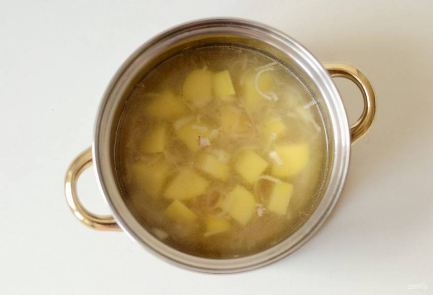 Картофель очистите от кожуры, нарежьте кубиками. Переложите в кастрюлю, влейте воду и доведите до кипения. Варите суп на среднем огне 15 минут.