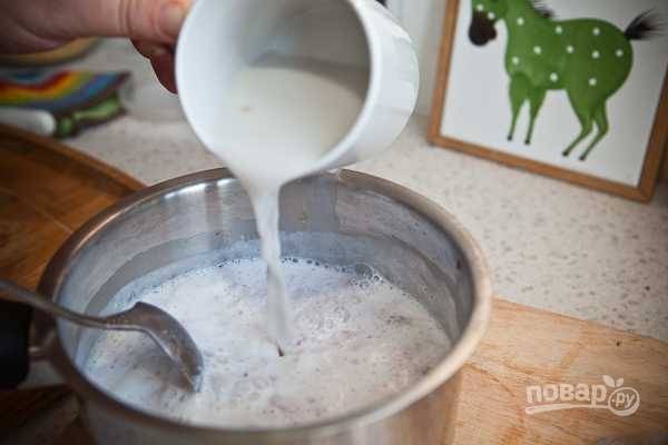 Когда молоко с малиной закипит, тонкой струйкой влейте разведенный крахмал.