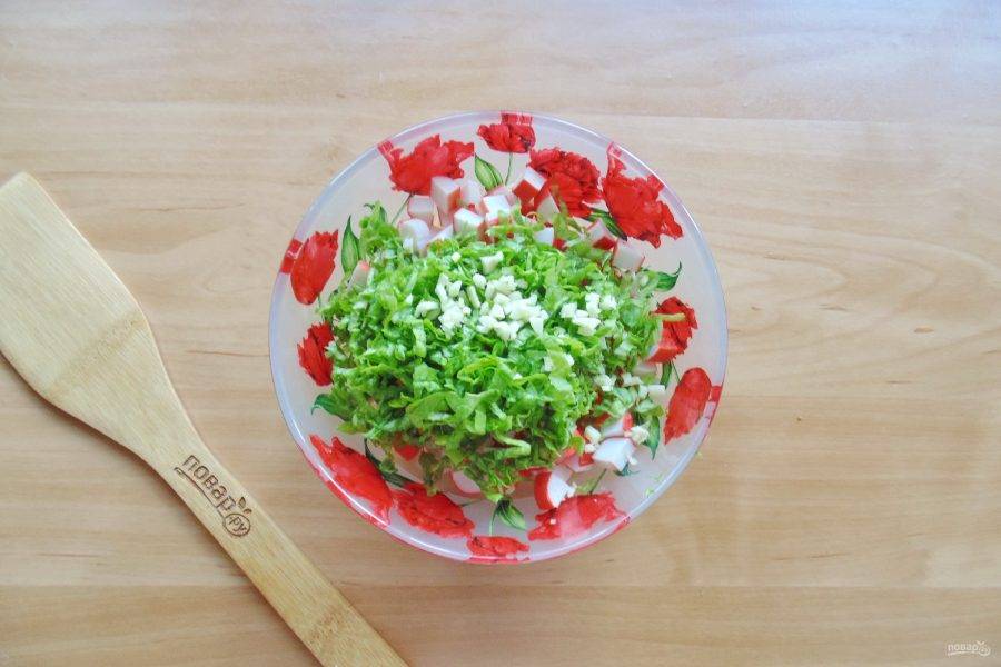 Листовой салат нарежьте соломкой, чеснок измельчите любым способом.