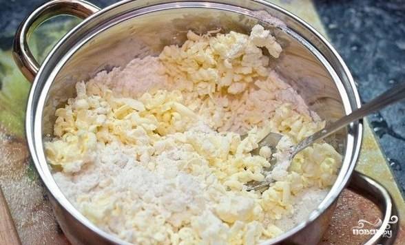 Готовим тесто. Треть измельченного миндаля, муку и сахар смешиваем. Масло достаем из морозилки и натираем на крупной терке. Быстро размешиваем и добавляем яйцо. Если тесто не собирается в комок, можно добавить немного сметаны. Отправляем тесто в холодильник на 30 минут.