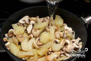 Добавить грибы к картошке и влить стакан тёплой кипячёной воды и продолжать тушить под крышкой около 10-12 минут.