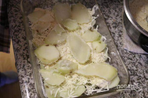 Полейте соусом и снова выложите слой картошки. Посыпьте смесью сыров.