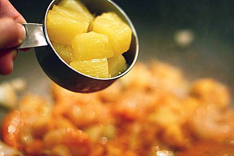 5. С консервированных ананасов слить сироп. Если ананасы кольцами, порезать небольшими кубиками и отправить на сковороду. 