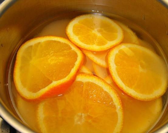 Тонко порезать неочищенные апельсины, положить их в кастрюлю с 400 мл воды и сахаром. Перемешать и готовить апельсины, накрыв крышкой, на плите, в течение 20 мин, пока корка не будет мягкой, если проткнуть ее острым ножом. Снять с огня и дать остыть.