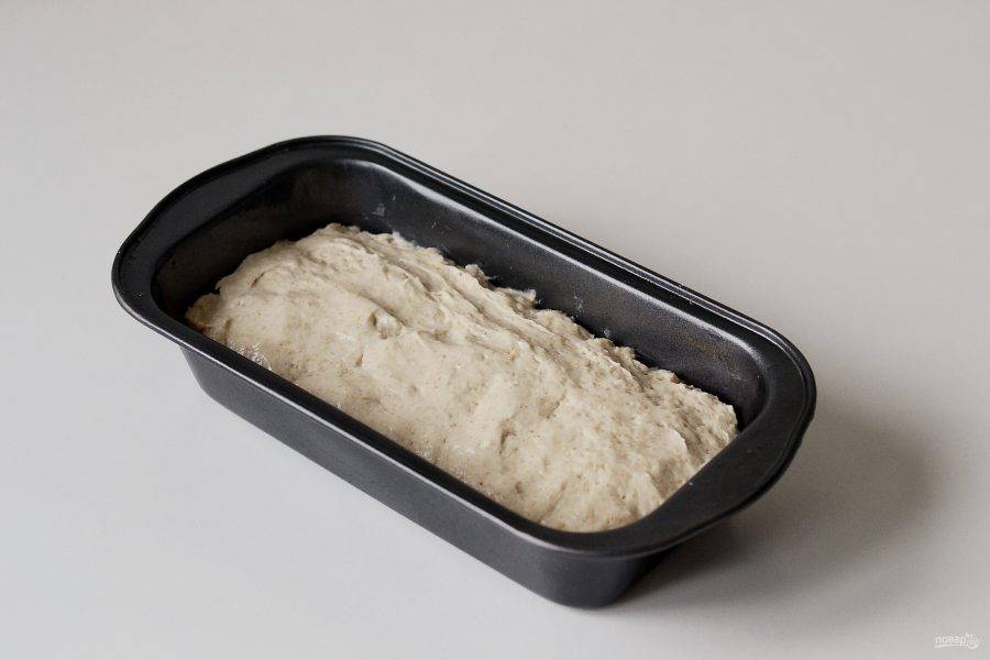 Мокрыми руками соберите тесто, переложите его в хорошо смазанную маслом форму. Накройте пленкой и оставьте примерно на 1 час подниматься. Тесто должно увеличиться в два раза. 
