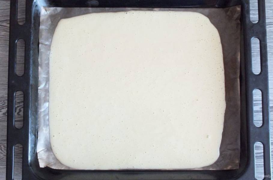 Возьмите противень. Застелите пергаментной бумагой, которую хорошо смажьте маслом. Вылейте тесто на противень, разровняйте лопаткой. Поставьте в разогретую до 200 градусов духовку на 7-10 минут. Учитывайте особенности своей духовки!