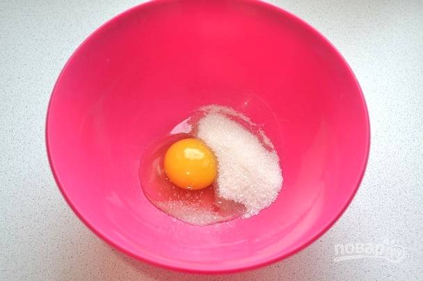 2. В глубокую миску вбейте яйцо, добавьте соль и сахар.