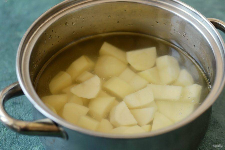 Картофель помойте, очистите от кожуры, нарежьте ломтиками. Отварите в кипящей подсоленной воде до мягкости.