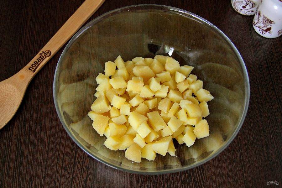 Картофель, сваренный в кожуре, очистите и нарежьте небольшими кубиками.