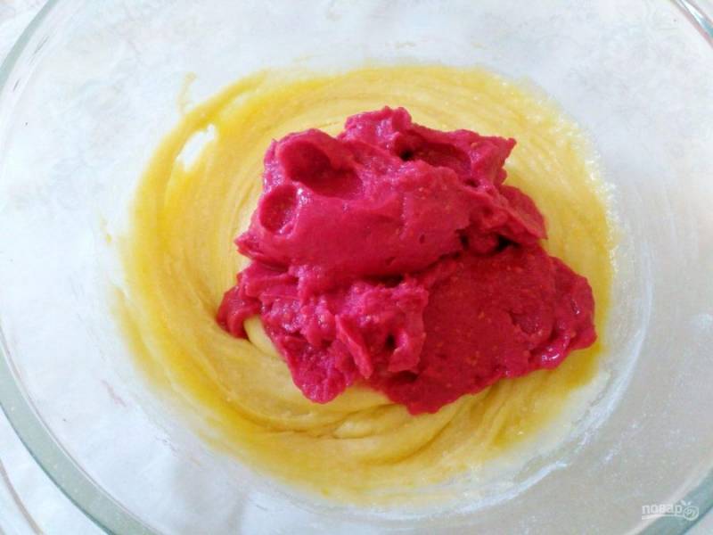 При помощи блендера превратите малину в пюре (в данном случае используются предварительно замороженные ягоды, но это необязательно) и добавьте в тесто, перемешайте.