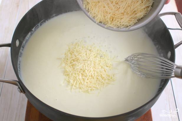 6. Томите соус, помешивая, 2-3 минуты. За это время натрите на терке сыр и добавьте на сковороду. Также в рецепт приготовления спагетти с курицей в сливочном соусе можно использовать плавленый сыр. 