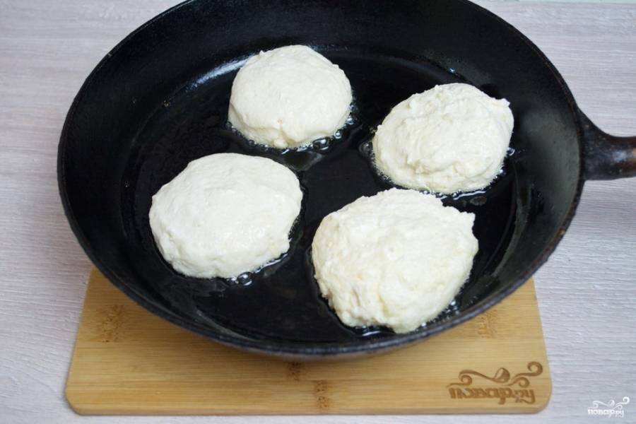 Мокрыми руками сформируйте из теста сырники. Разогрейте сковороду. Влейте немного растительного масла, обжарьте сырники на сковороде с двух сторон до румяности.