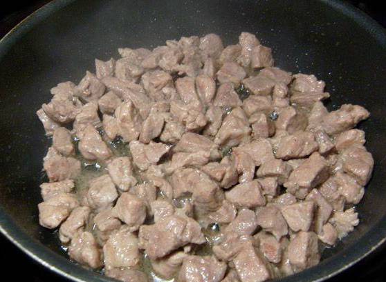 Промываем мясо и режем небольшими кубиками. Смазываем маслом глубокую сковородку, ставим на средний огонь. Мясо кладем на раскаленную сковороду и жарим до испарения жидкости.