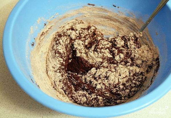 Все сухие ингредиент добавьте в полученную масляно-шоколадную смесь. Перемешайте хорошенько. 