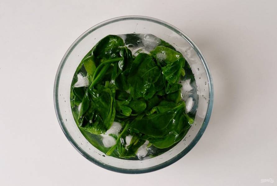 Шпинат помойте, отварите в кипящей воде 1-2 минуты. Затем опустите шпинат в заранее подготовленную миску с холодной водой и кубиками льда (это поможет сохранить яркий зеленый цвет шпината). Откиньте шпинат на дуршлаг.