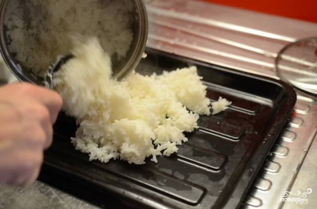 Когда рис стал мягким и вобрал всю воду, выложите его на плоскую неметаллическую посуду.