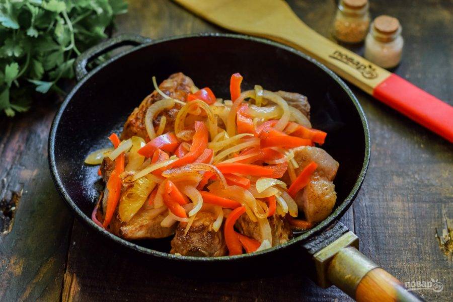 Отдельно обжарьте лук и перец — 3-4 минуты, после добавьте овощи в сковороду с мясом. Перемешайте и тушите 30 минут под крышкой.
Свиные ребрышки по-корейски готовы.