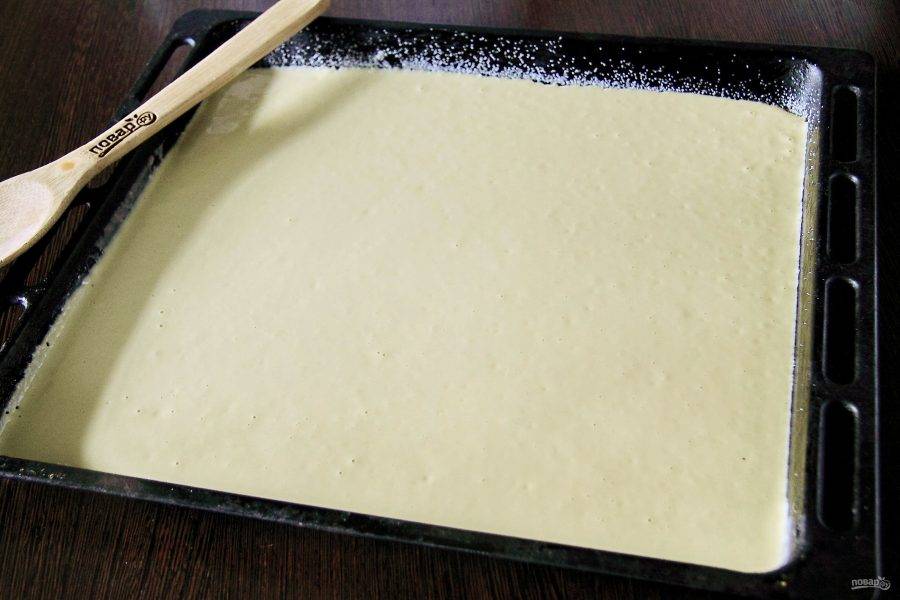 Противень смажьте маслом и присыпьте дно и бока манкой. Вылейте тесто.