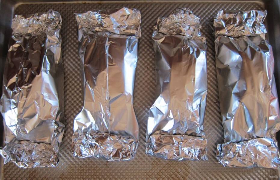 По вкусу сверху положите по кусочку сливочного масла, плотно заверните фольгу конвертиками и отправьте в духовку, разогретую до 200 градусов, на 20 минут.