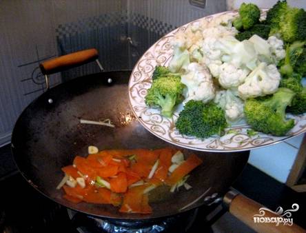Приступаем к овощам. Нарезаем морковь, чеснок, репчатый лук или лук-порей на тонкие ломтики. Промываем соцветия цветной капусты и брокколи. Обжариваем лук, чеснок и морковь в соке, который остался из-под мяса. Докладываем цветную капусту с брокколи. Подливаем соевый соус и тушим все 5 минут. 