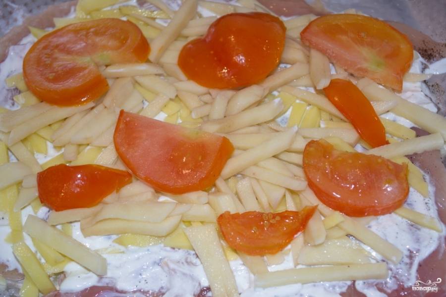 Нарежьте помидоры кружочками или полукругом. Распределите их тоже равномерно. Запекайте блюдо в духовке при 180 градусов около 40 минут.