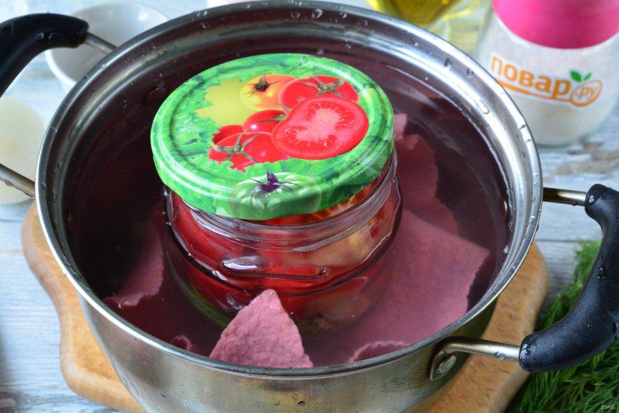 Влейте в банку уксус и залейте помидоры кипятком. Поставьте банки стерилизоваться на 5 минут в кастрюлю с водой.
