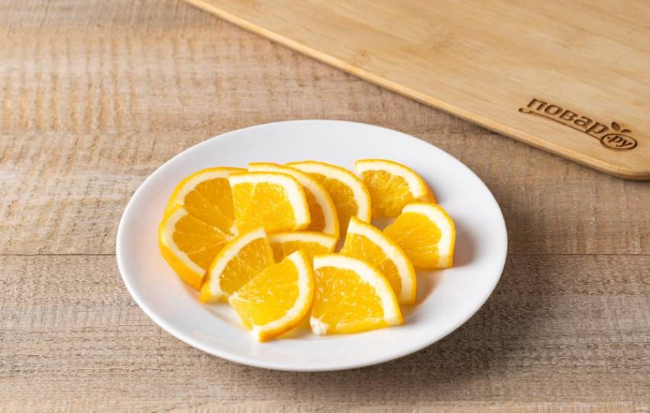 Апельсин помойте и нарежьте тонкими кружочками. Удалите по необходимости косточки, а кружочки разрежьте на 4 части.