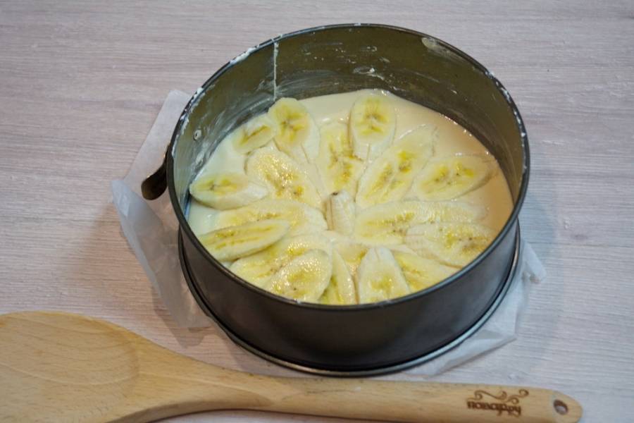 5. Нарежьте на кусочки бананы. Выложите их произвольно на сырое тесто. Чем больше бананов, тем вкуснее будет выпечка. Два банана вполне достаточно.