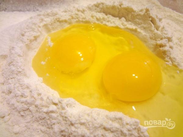 2.	Около 250 грамм муки просейте в миску, добавьте в центр яйца и соль.