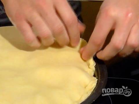 Аккуратно уложите тесто на яблоки, заправьте кончики теста по всей форме.