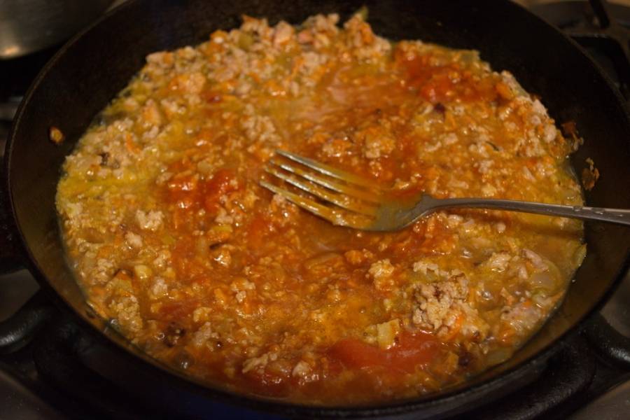 К зажарке из моркови и лука добавьте сырой фарш. Влейте томатный соус (или сок). Тушите все вместе около 10 минут. Добавьте соль и специи по вкусу.