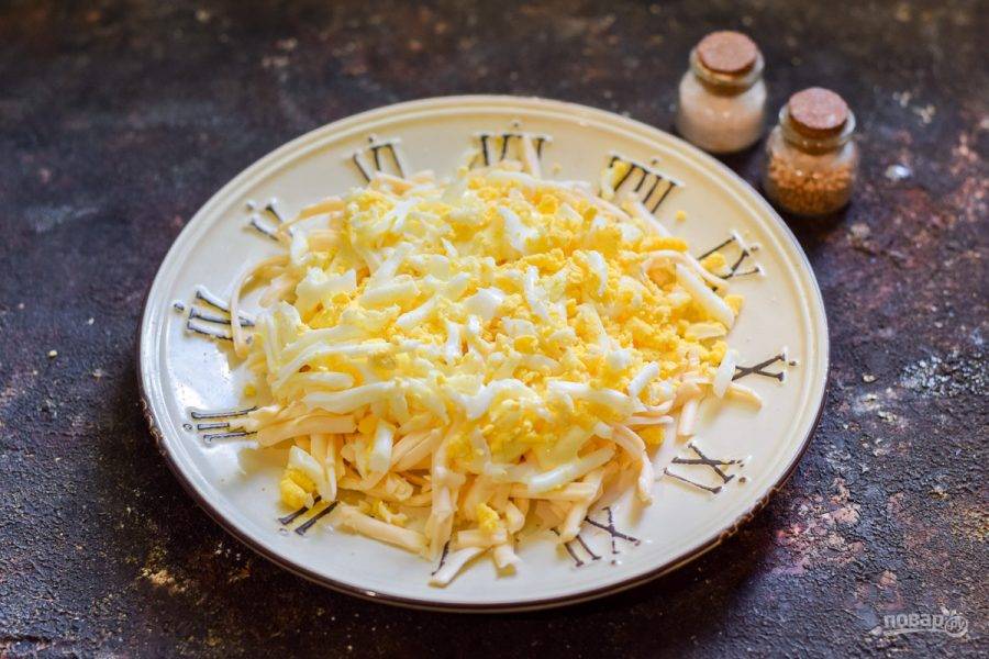 Куриное яйцо отварите и натрите на средней терке, выложите поверх сыра — это будет второй слой салата. Далее смазывайте каждый слой небольшим количеством майонеза.