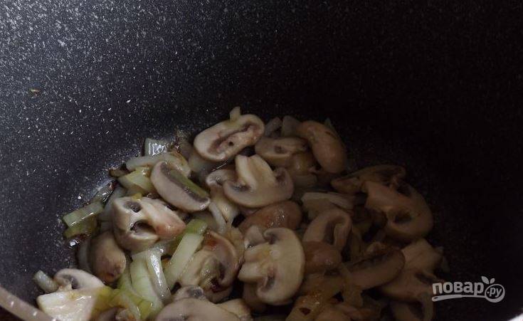 Возьмите сотейник и влейте в него растительное масло без запаха. Разогрейте масло на плите и выложите в сотейник подготовленные грибы и лук. Обжаривайте овощи в течение нескольких минут. 