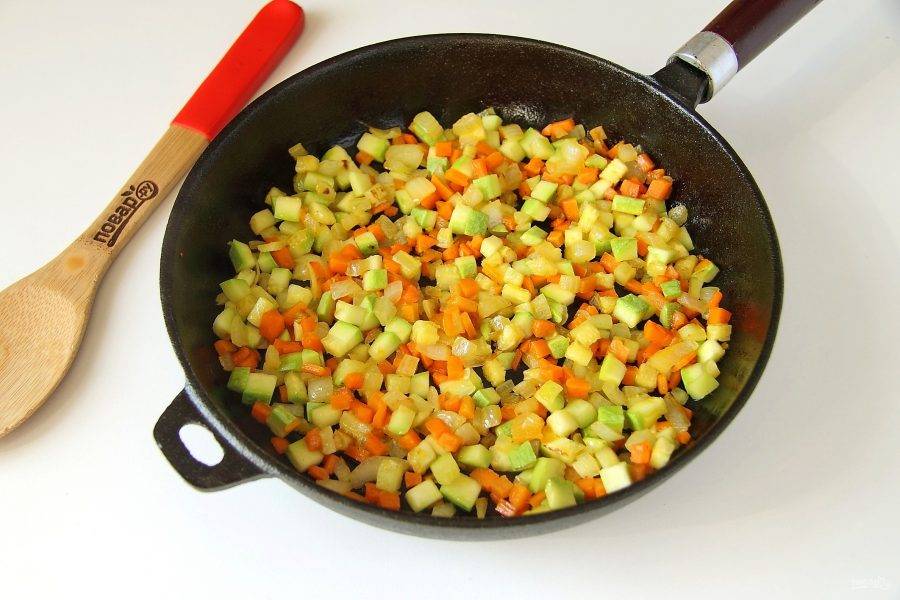 Налейте в сковороду масло, добавьте лук и морковь. Обжарьте примерно в течение 2-3 минут, периодически помешивая, до мягкости. Затем добавьте кабачок и готовьте овощи еще пару минут. Если кабачок зрелый, то предварительно очистите его от кожуры и удалите семечки.