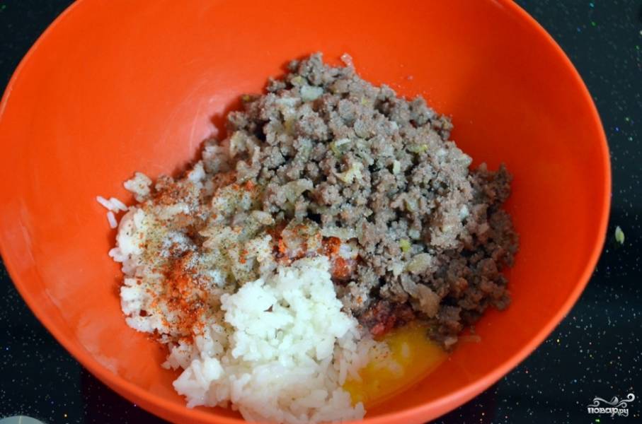 2. Обжаренный фарш с луком и чесноком выложите в миску. Рис отварите до готовности в подсоленной воде. Рис остудите и добавьте к фаршу. Вбейте туда же одно яйцо, добавьте соль, перец. Перемешайте.