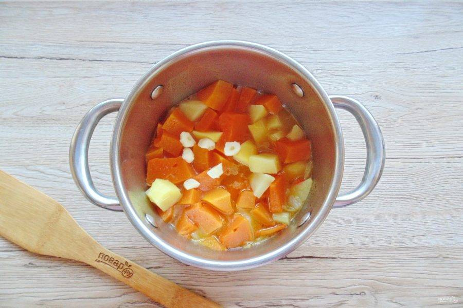В готовые овощи добавьте очищенный и мелко нарезанный чеснок. Взбейте всё блендером до консистенции пюре.