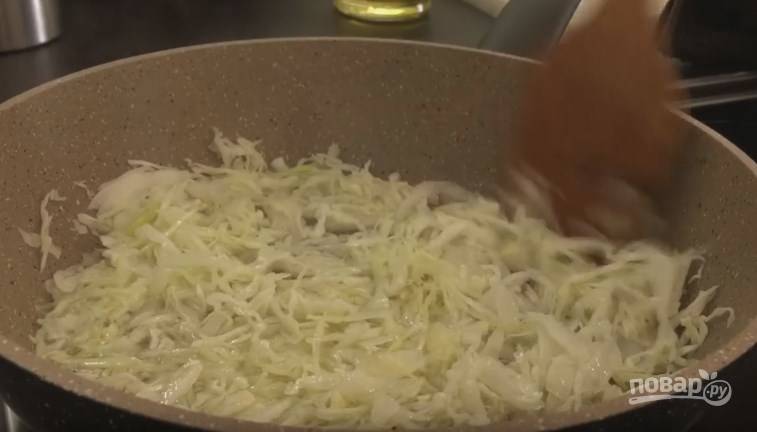 4. На вторую сковороду добавьте немного масла, а затем отправьте туда нашинкованную капусту, чтобы она немного потушилась. 