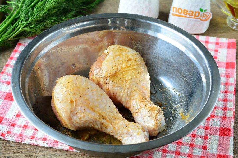 Куриные голени промойте, просушите на салфетках. Выложите курицу в глубокую ёмкость. Натрите солью, черным перцем и приправой карри.