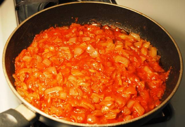 В этой же сковороде обжариваем лук до прозрачности, затем добавляем паприку и томатную пасту+2 ст.л. воды, тщательно перемешиваем и тушим 5 минут.