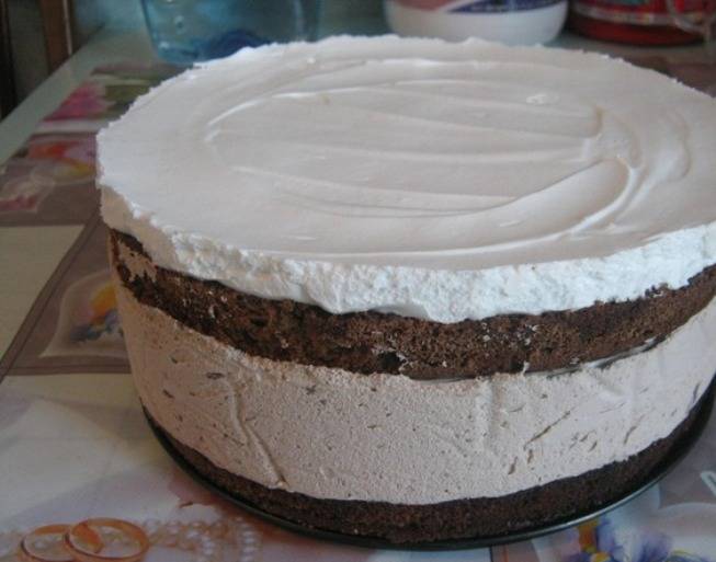 Теперь выложите его между коржами торта, украсьте его по своему вкусу и поставьте торт с начинкой из шоколадного мусса в холодильник на ночь. Чтобы мусс не растекся, оберните нижний корж по кругу пергаментом, затем выкладывайте мусс, а сверху накройте вторым коржом. Бумагу не убирайте, пока не вынете торт из холодильника. 