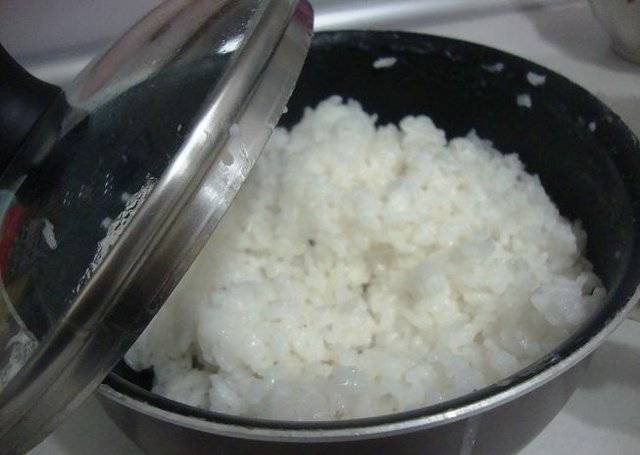Варим рис. Для этого заливаем рис 1,5 стаканами воды и ставим на огонь. Доводим до кипения и уменьшаем огонь до самого маленького. Варим под крышкой минут 10-13, до тех пор, пока вся вода не впитается. Потом выключаем огонь и оставляем рис еще минут на 10. Можно добавить в рис заправку из рисового уксуса, сахара и соли - как для суши, а можно оставить  и так.