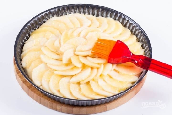 8.	Выкладываю яблоки на пирог по кругу, смазываю их глазурью из масла и сахара.