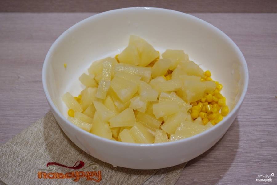Переложите кукурузу в миску. Достаньте ананасы из банки. Каждое колечко нарезаем на равные 12 частей. Я осознанно не беру нарезанные ананасы, в данном салате важно качество ананаса, а в нарезанных промышленных ананасах оно хуже.