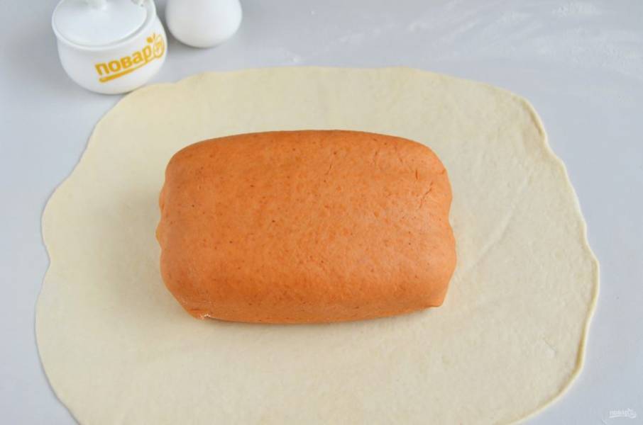 15. Теперь раскатайте белое тесто в пласт. Заверните в него хлеб. Края защипните.