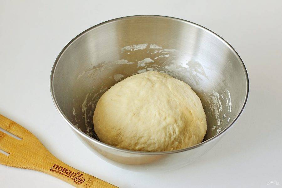 Замесите тесто. Муки может уйти чуть меньше, чем указано в рецепте, готовое тесто должно быть упругое и эластичное. Соберите его в шар, накройте полотенцем и дайте полежать 20-30 минут.