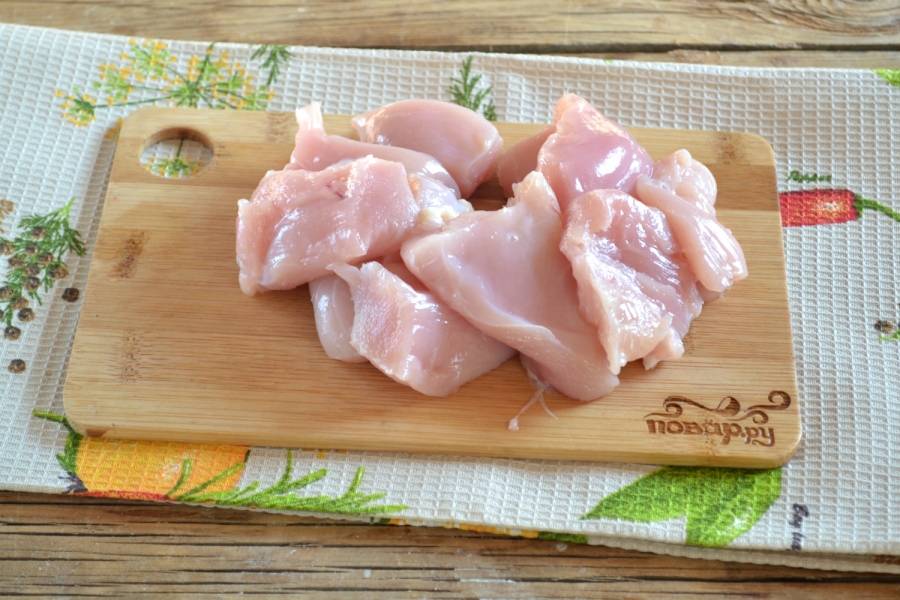 2. Куриную грудку промойте и порежьте на небольшие куски. Выложите курицу в хорошо разогретую сухую сковороду, обжарьте её в течение 3-5 минут, чтобы сверху она побелела, а весь сок остался внутри.