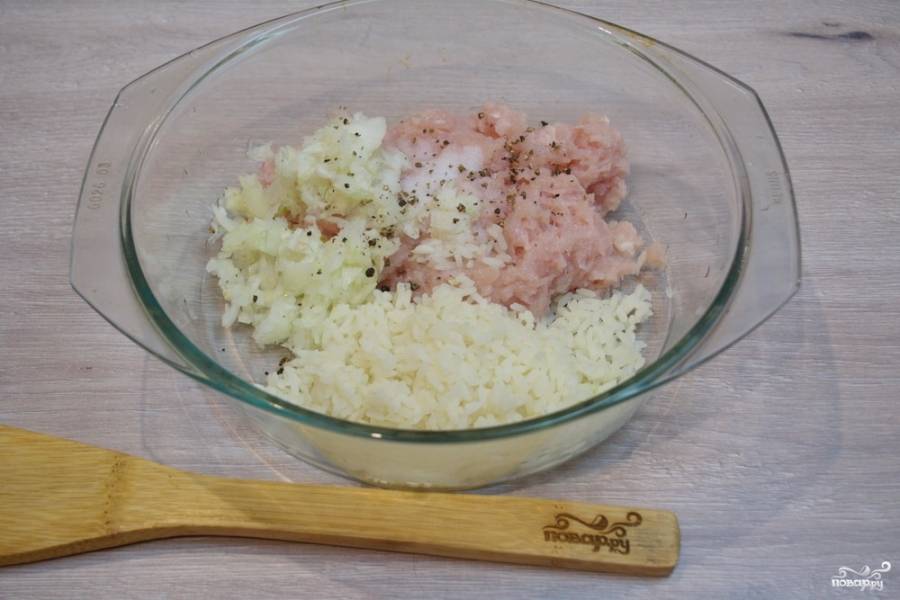 Куриное мясо перекрутите в фарш. Мелко нарежьте репчатый лук. Слегка проваренный рис (полусырой) откиньте на сито. Дайте стечь жидкости. Остывший рис добавьте к фаршу.