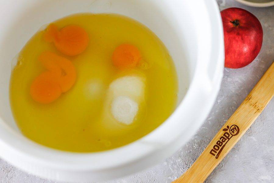 Вбейте куриные яйца в чашу кухонного комбайна или глубокую емкость, всыпьте сахар и соль.