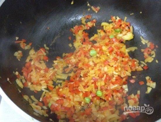 Перекладываем обжаренного кролика в посуду, в которой будем тушить наше блюдо. А на сковороду добавим растительного масла, обжариваем минут 5 перец с репчатым луком.
